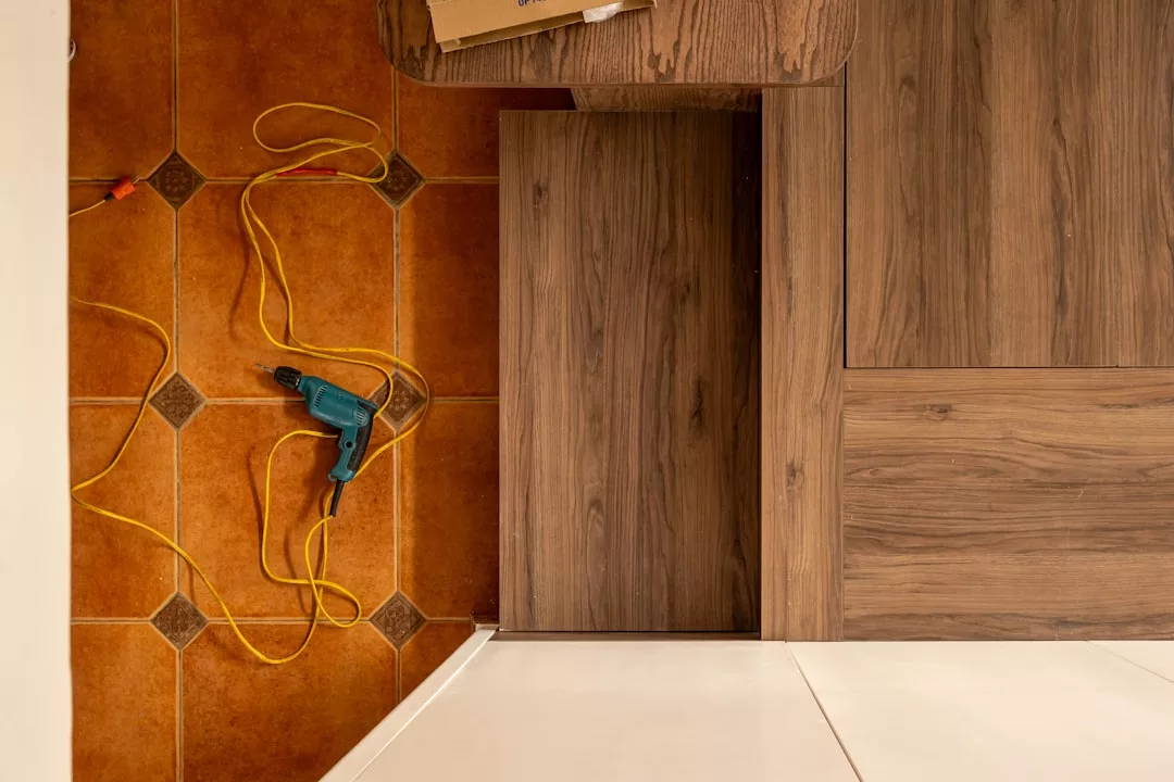 Une boîte à outils ouverte posée sur un sol en bois, à côté d