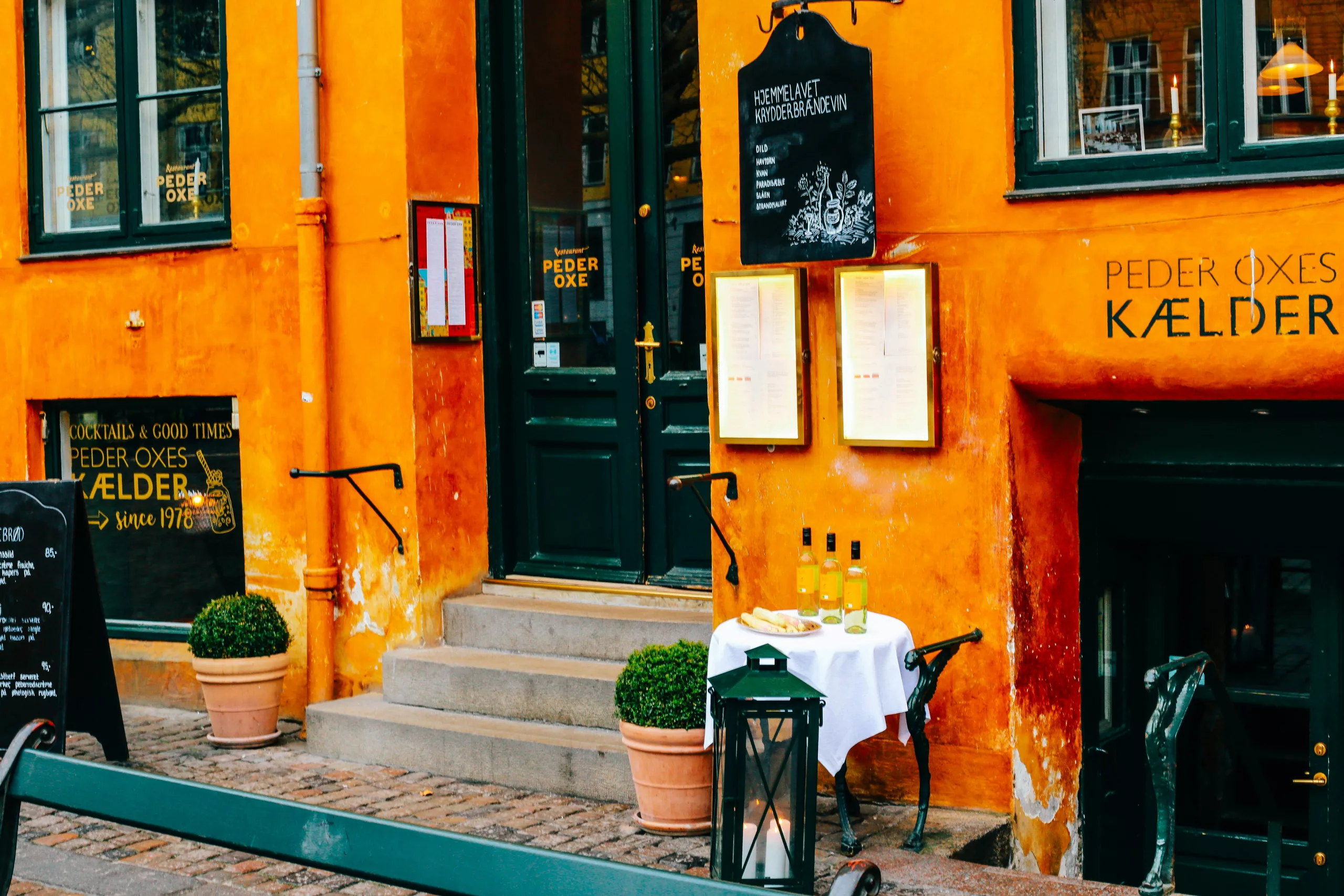 Une ruelle pavée pittoresque dans un centre-ville historique européen, bordée de bâtiments colorés et de cafés avec terrasses, suggérant une expérience locale authentique.