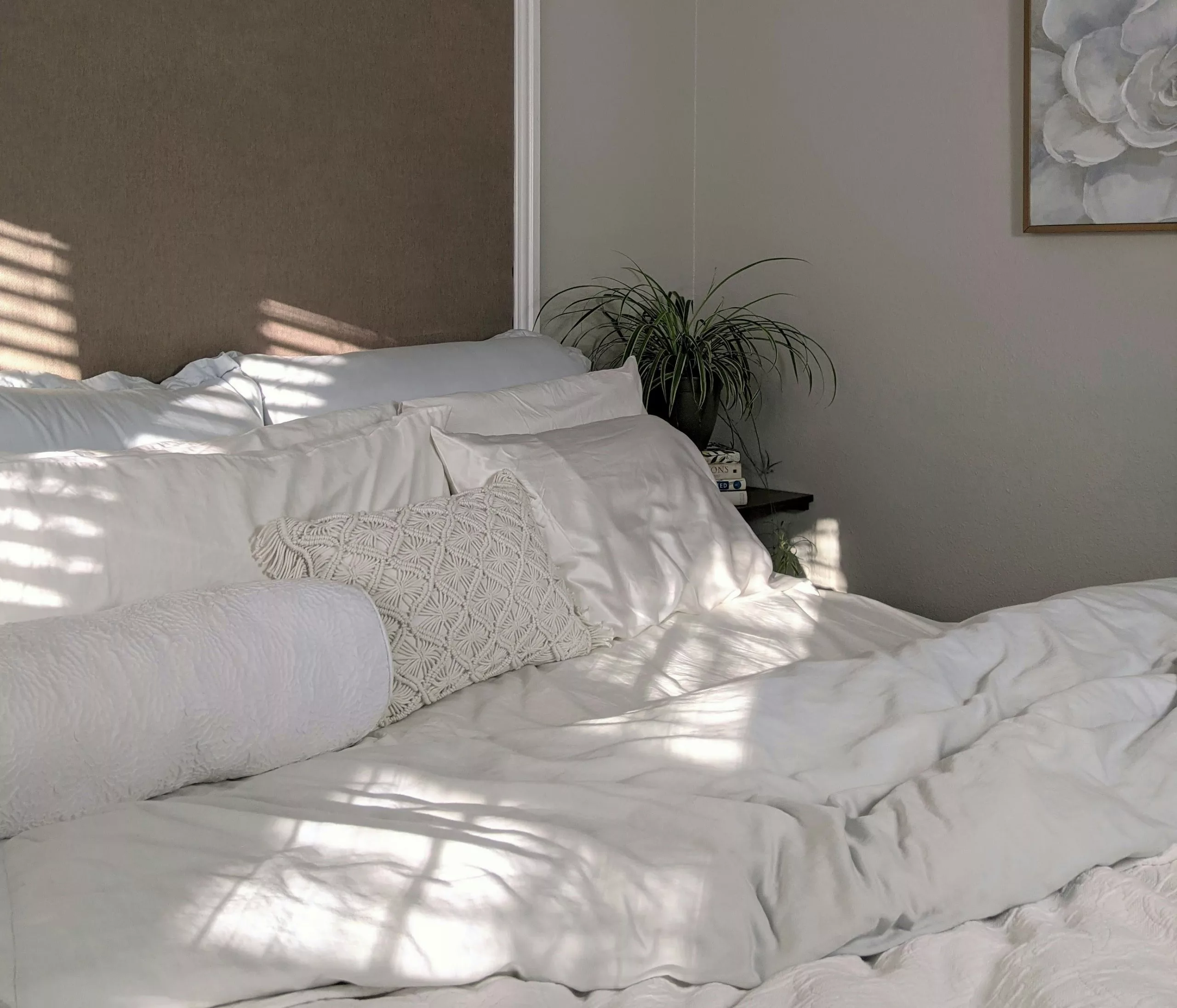 Elegant minimalist bedroom decor with white sheets and wood accents in Airbnb rental