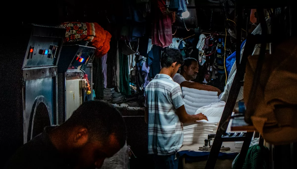 Men working in a laundry service with folded clothes.