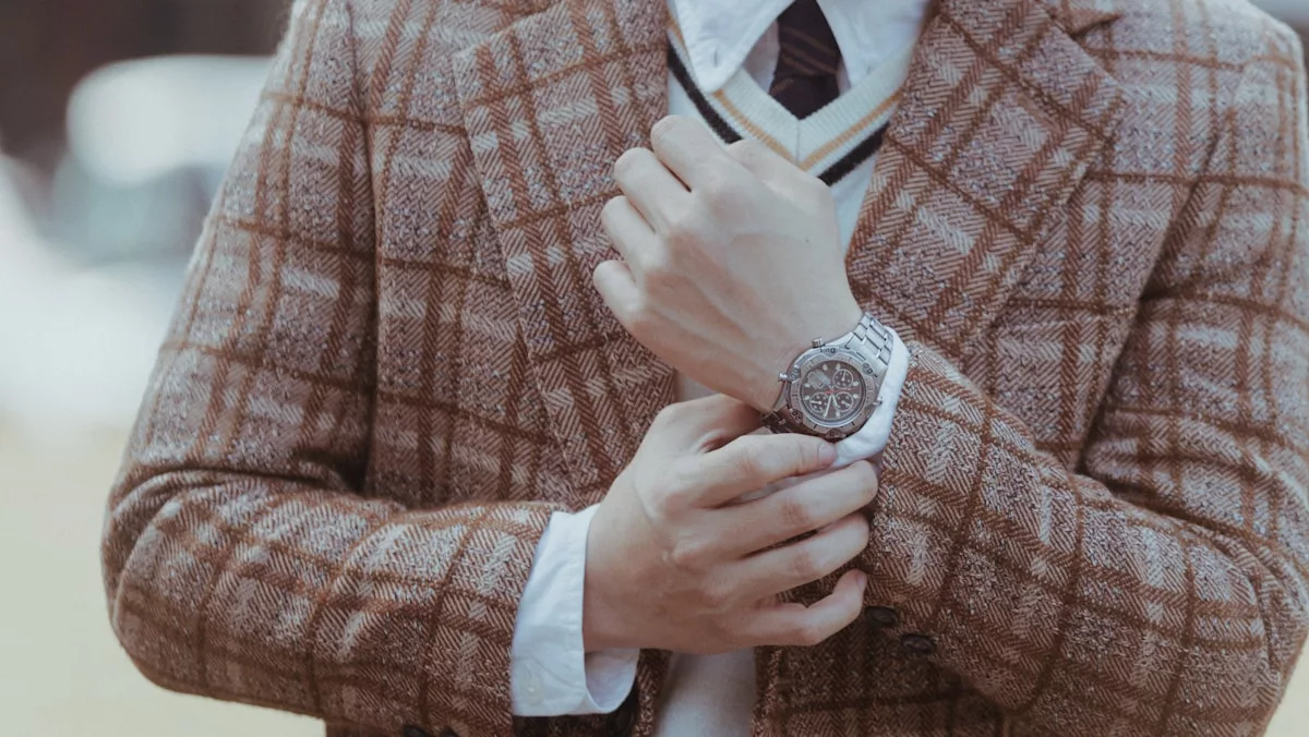 A man in a suit and tie is holding a watch