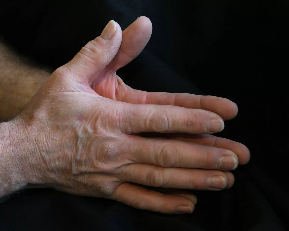 a person's hands with a black background