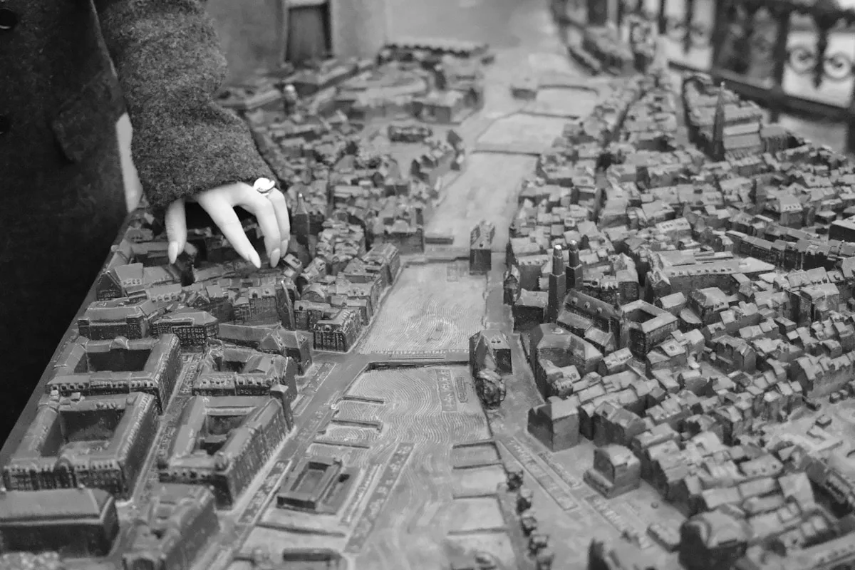 Hand touching a detailed architectural model of a city