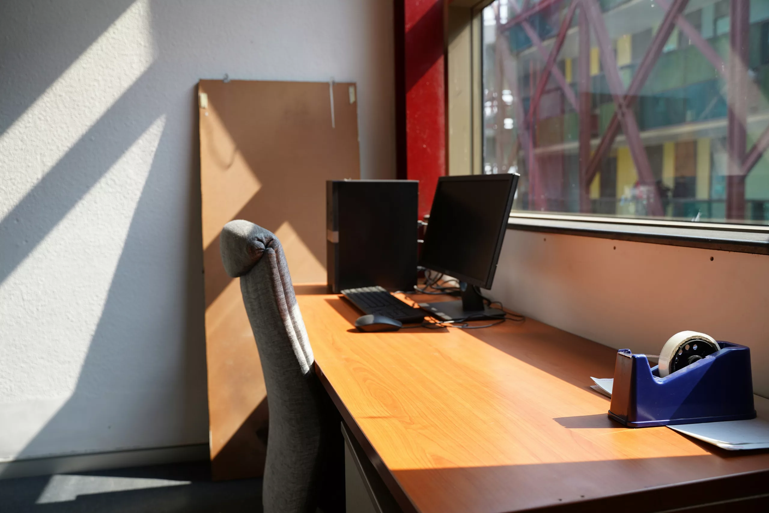 Une personne en tenue professionnelle assise à un bureau en bois, examinant attentivement un document contractuel avec u...