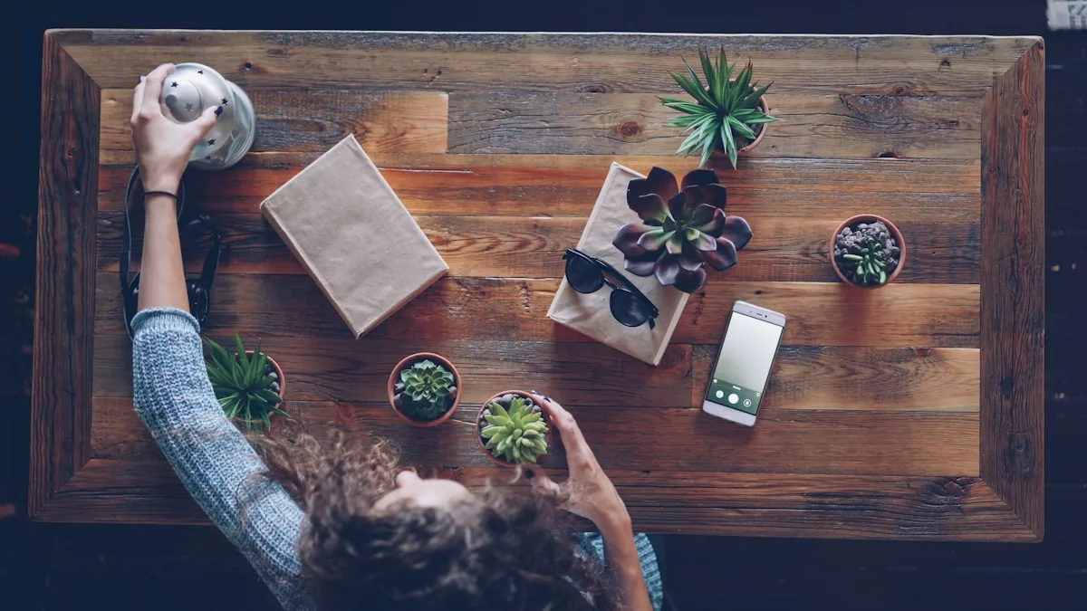 Une femme disposant des plantes sur une table en bois.