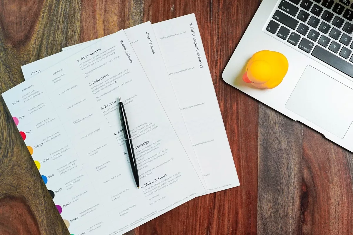 Formulaire de demande d'emploi sur un bureau en bois avec un ordinateur portable et un citron.